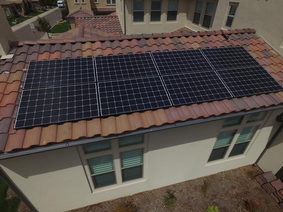Black solar panel array on a tile roof